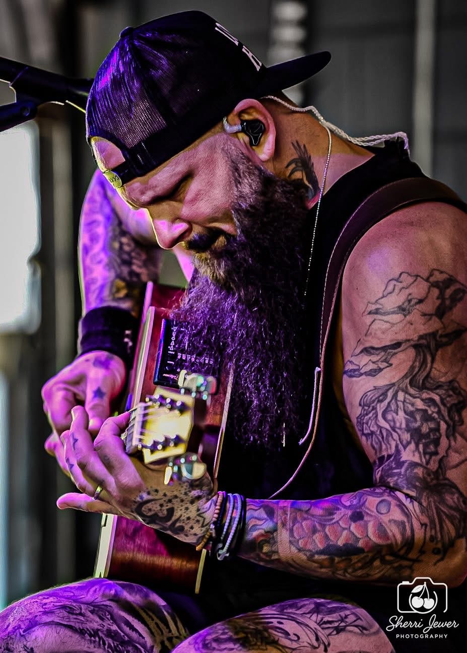 Rob Benton playing acoustic guitar under purple stage lights, photographed by Sherri Lewer Photography