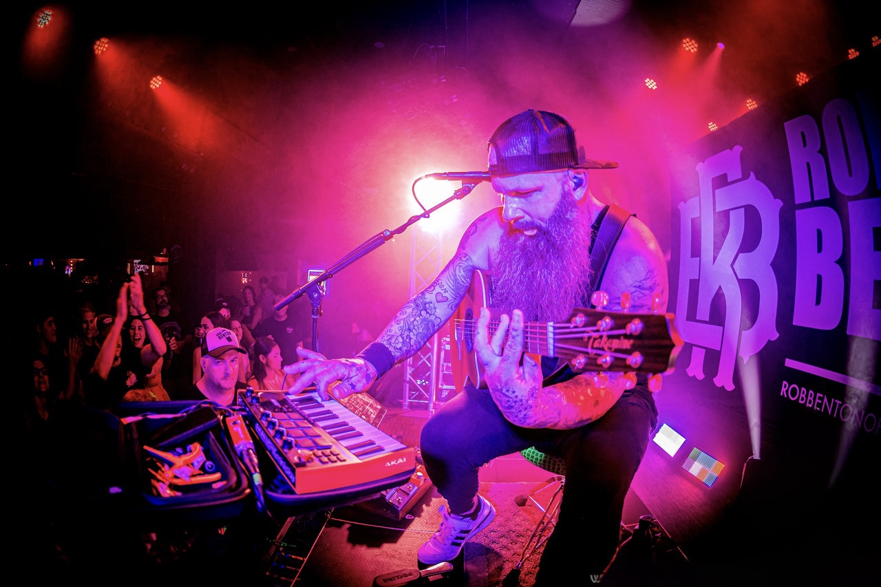 Rob Benton performing with guitar and live looping equipment in front of an audience